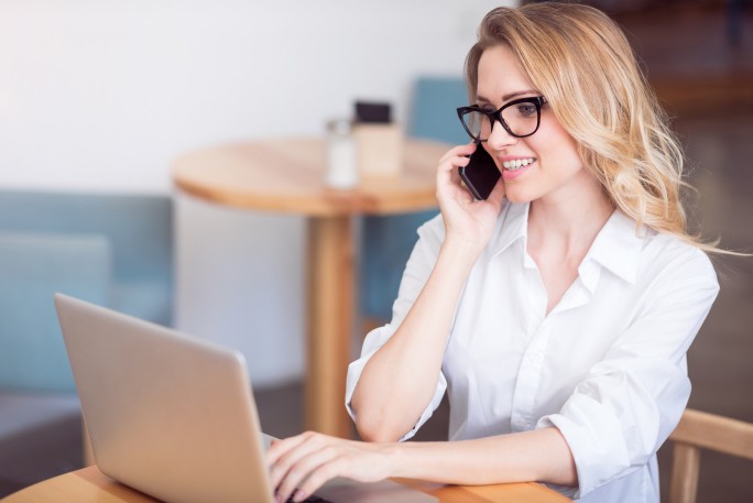 Frau mit Laptop und Smartphone