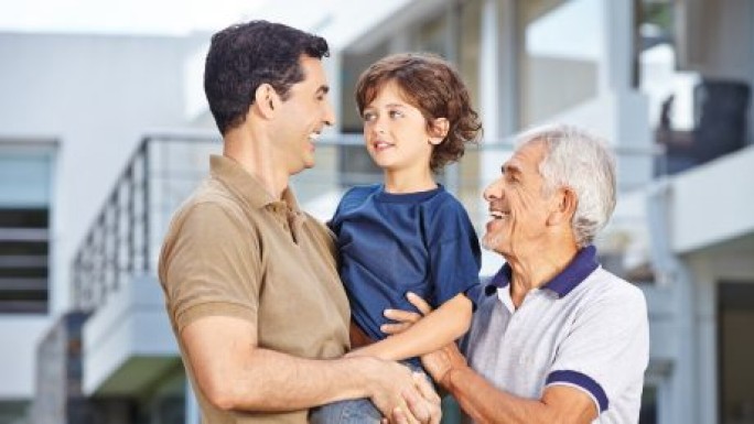 Drei Generationen vor einem modernen Haus